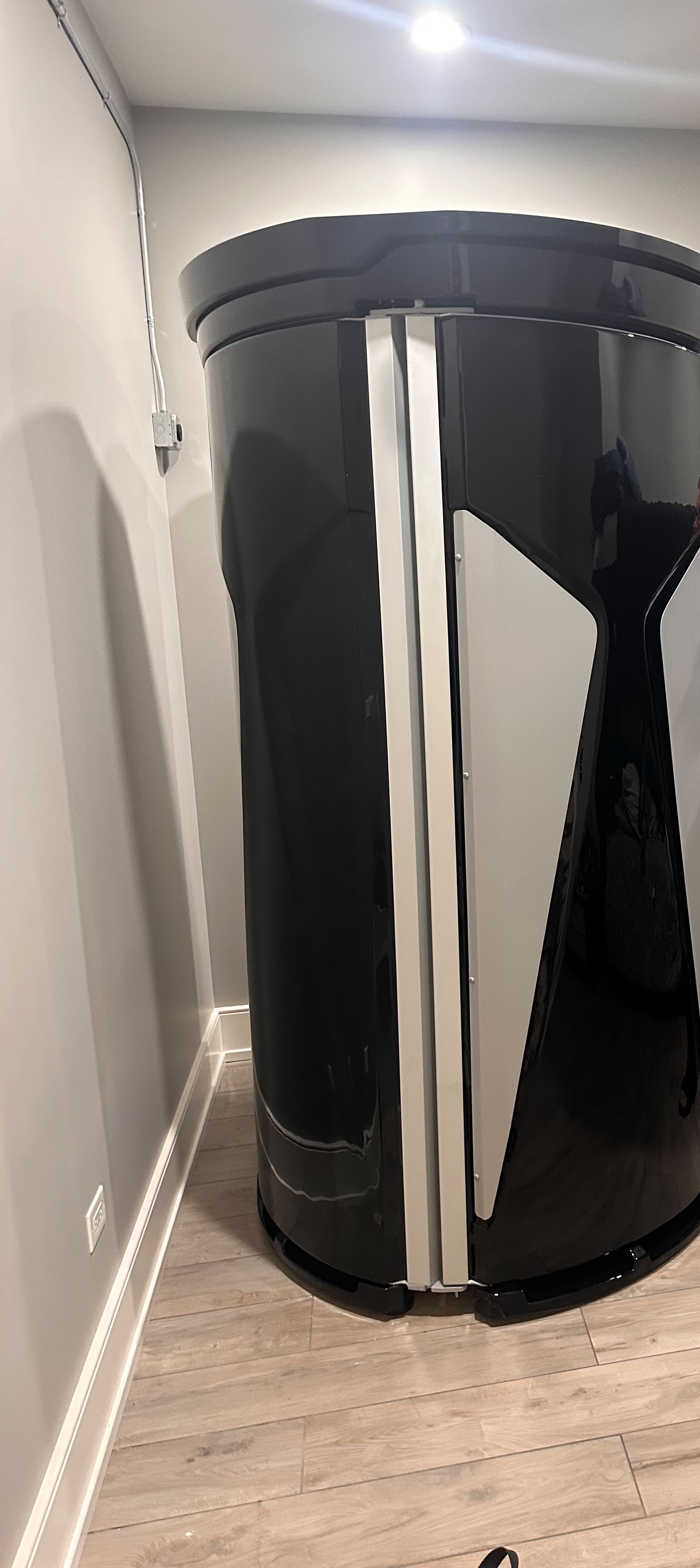 A privacy-cropped view of a standalone upright light booth in a private room